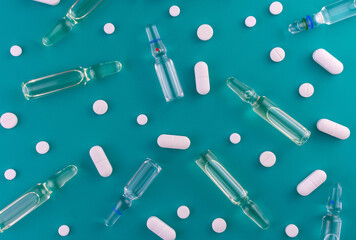 Medical background from tablets and ampoules for injections on a blue background.