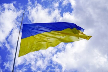 The yellow blue flag of Ukraine flutters against the sky. Symbol of Ukrainian people and freedom