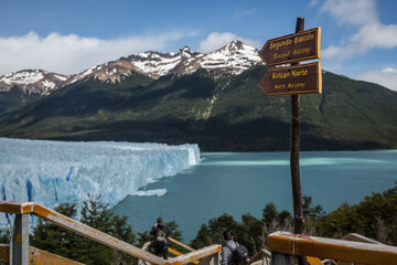 Ein hölzerner Wegweiser an einer Besucherplattform am Perito Moreno Gletscher, im Hintergrund  das...