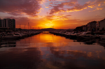 Fototapeta na wymiar amazing colorful clouds on sunset. Beautiful golden sunset in the sea with saturated sky and clouds. Reflection in the water. Rocky coastal line. Peaceful serene landscape. Nature background.