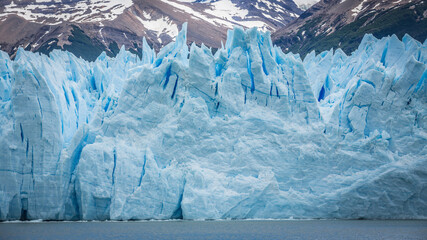 Frontalansicht auf eine riesige Wand aus Eis. Eisspitzen und große Risse des Perito Moreno...