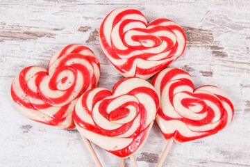 Sweet funny lollipop in shape of heart on old rustic board. Surprise for child. Memory of childhood
