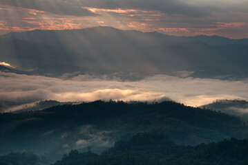 Beautiful sunlight ray over a mountain range and sea of fog in a valley