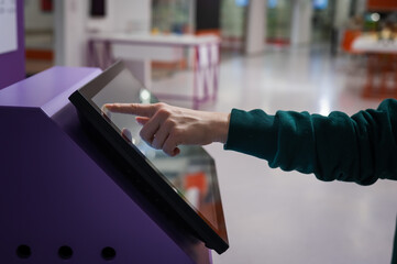 Close-up of a woman using a touch screen information booth.