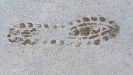 Human footprint on road surface. Foot steps leaving footprints.