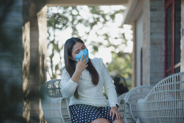 Fototapeta premium Young Asian woman wearing protection face mask prevent Corona Virus Disease (Covid-19). Infection and Pandemic concept