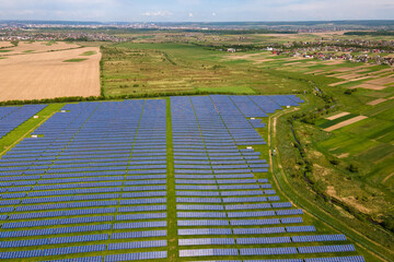 Aerial view of big sustainable electric power plant with many rows of solar photovoltaic panels for producing clean ecological electrical energy. Renewable electricity with zero emission concept