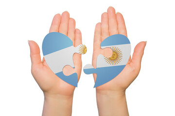 Woman hands are holding two parts of puzzle heart. National concept on white background. Argentina
