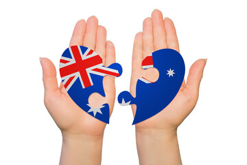 Woman hands are holding two parts of puzzle heart. National concept on white background. Australia