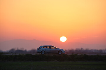 Car driving fast on intercity road at sunset. Highway traffic in evening