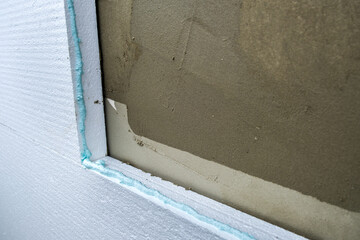 Installation of styrofoam insulation sheets on house facade wall for thermal protection