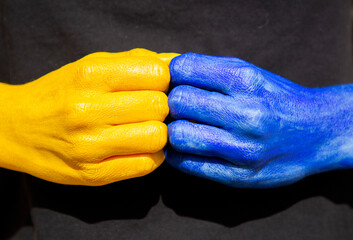 female hands in fists are painted in colors of the Ukrainian flag. readiness to fight for freedom...