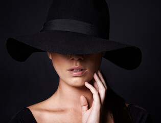 Shes a mystery youd like to unravel. Portrait of an attractive woman wearing a black hat.