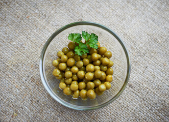 Green Peas in a clear glass bowl, close up