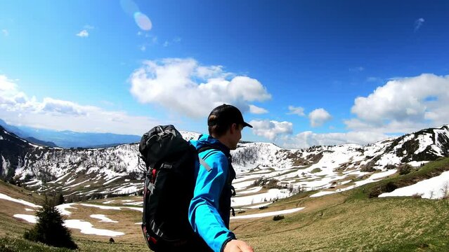 Man taking selfies and hiking to the Frauenkogel (Dovska Baba) with scenic view on the Karawanks, Carinthia, Austria. Borders Austria, Slovenia, Italy. Triglav National Park. Mount Triglav and Mangart
