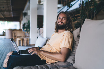Portrait of skilled hipster guy with laptop technology working remotely using 4g wireless internet...