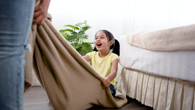 4K 50fps, An adorable Asian girl with two hair tied up, playing with her sister dragging the blanket in the living room of her house, having fun.Family and Healthy.