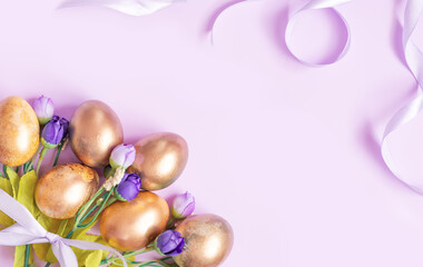 Golden Easter eggs with flowers on a lilac background . Easter concept with space for text