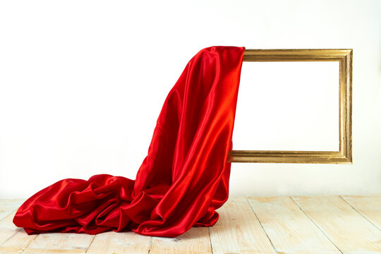 red satin cloth unveiling a golden frame. Levitating frame, mockup for presentation.