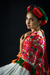 Mexican teenager dressed in Huasteca Potosina costume from the state of San Luis Potosí Mexico, traditional embroidery and multicolored yarn petob