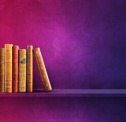 Row of old books on purple shelf. Square background