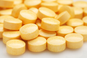 Yellow pills on white background, closeup