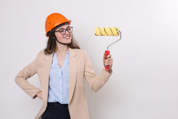 Girl engineer in an orange construction helmet with plastering painting tools in her hands on a white background.