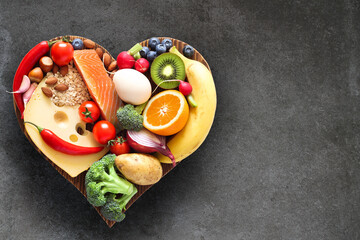 Balanced diet. Healthy food on a heart-shaped wooden cutting board.