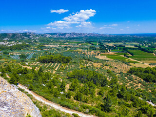 Fototapeta na wymiar Magnificent landscape with a view of the fields, nature and the Alpilles from the heights of Baux de Provence in Provence in France 