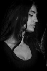 Naklejka premium Black and white portrait of a beautiful Italian girl with long hair in profile looking down