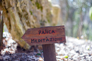 Wood Rustic signs direct to Meditation area Write in Italian language “Panca meditazione” meaning is Meditation bench.Santacittarama “forest sangha”Rieti, Lazio. Monastery, Buddhist Temple