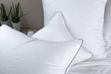 Fototapeta na wymiar A lot of white pillows lie on the bed of the bedroom. Contemporary bedding