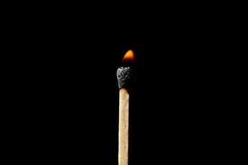 Burning matchstick on black background. Emotional burnout concept