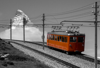 Famous narrow gauge gear train “Gornergrat-Bahn“ climbing up to mountain station with panoramic...