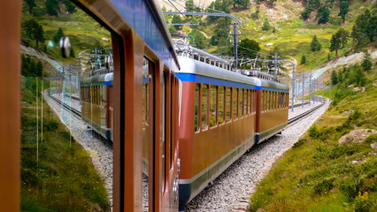 Famous narrow gauge gear train “Gornergrat-Bahn“ descending from mountain station with...