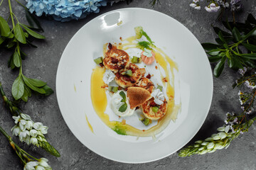 An ideal breakfast. Cottage cheese pancakes with caramel, almonds and cream sauce in a white plate. Ukrainian syrniki