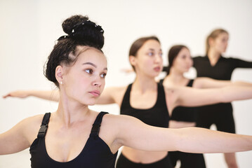 The trainer shows how to stretch correctly to a group involved in sports.