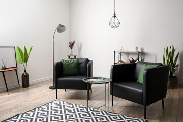Black armchairs with table in interior of modern living room
