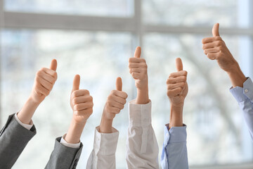 Business people showing thumbs-up in office