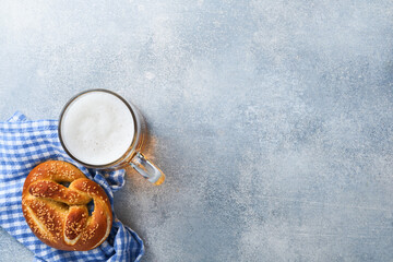 Bavarian pretzels and glass of lager beer. Oktoberfest food menu, traditional salted pretzels on light grey background. Top view with space for text. Oktoberfest theme