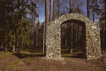 old medieval cemetery gate. Arch shaped building, no fence, entrance in abandoned Latvian burial ground made of dolomite stone pieces