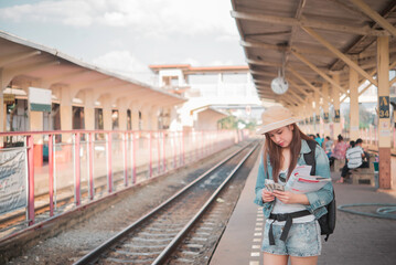 Asian tourist wait train at train station,thailand hipster womanman go to travel,Have a camera in hand