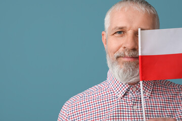 Mature man with flag of Poland on blue background, closeup