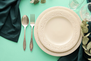 Elegant table setting with eucalyptus leaves on green background