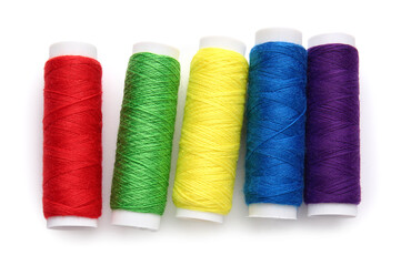 Different thread spools on white background