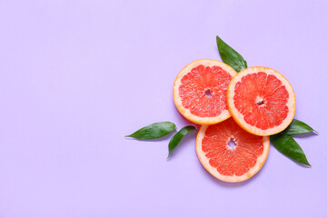 Fresh grapefruit slices on purple background
