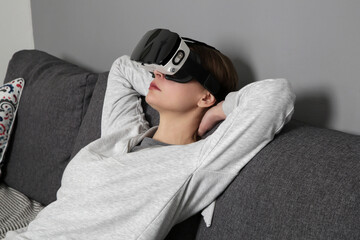 Portrait of woman with VR glasses in her livingroom. Virtual reality experience and future technology concept. 