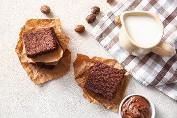 Pieces of delicious chocolate brownie on light background