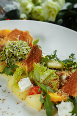 Summer diet salad with leaves of lettuce, watermelon, peach and feta cheese. On a light blue background copy space