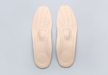 Pair of orthopedic insoles on grey background